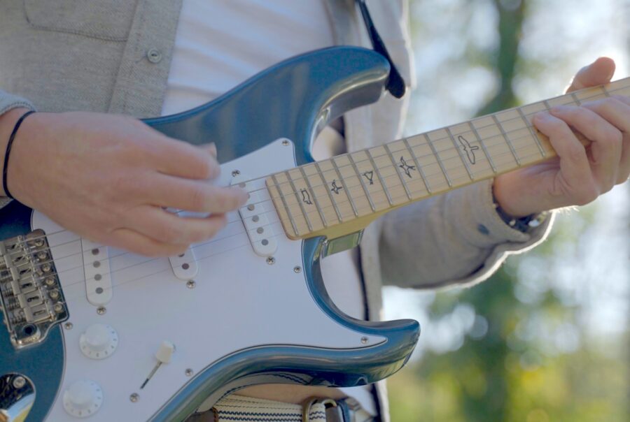 Person playing guitar at the Castle Studios 1 year anniversary party.
