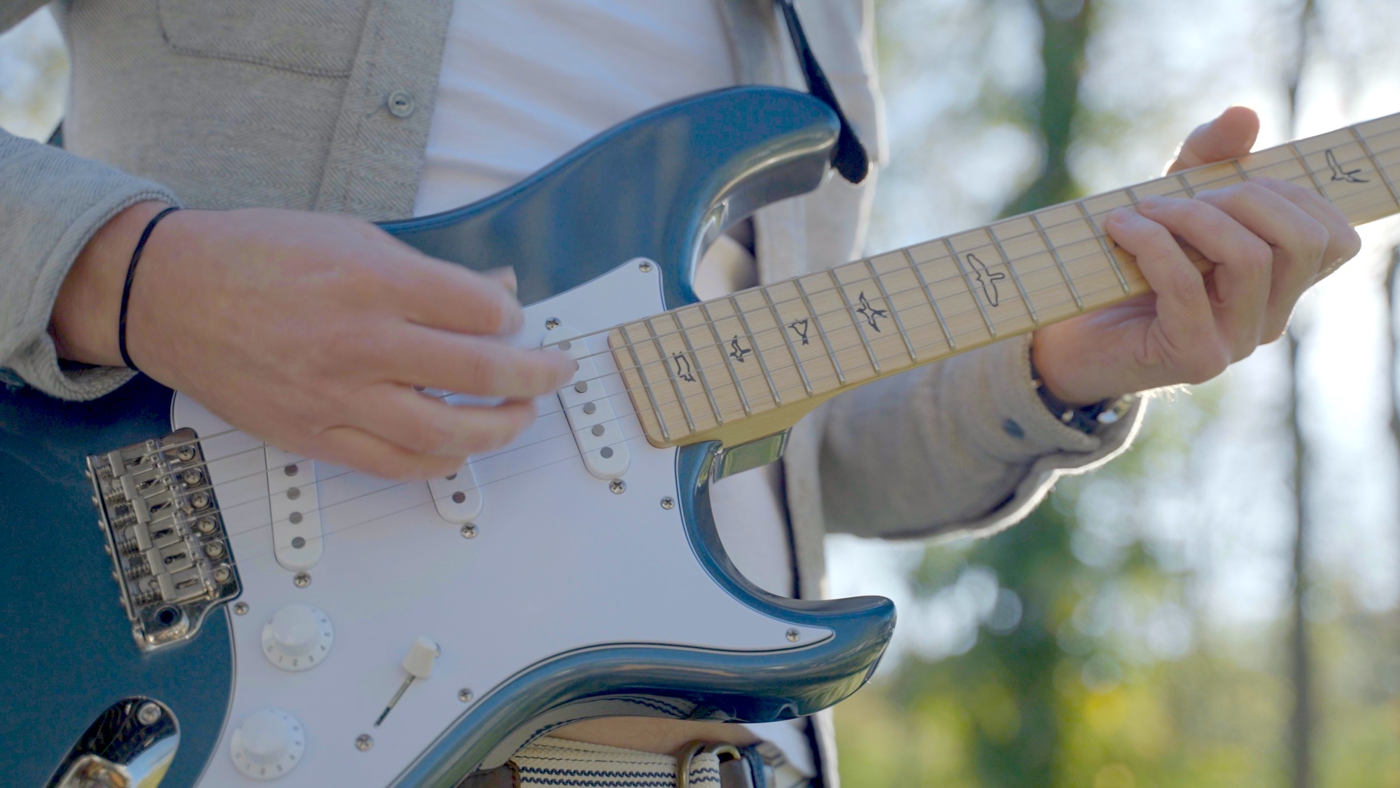 Person playing guitar at the Castle Studios 1 year anniversary party.